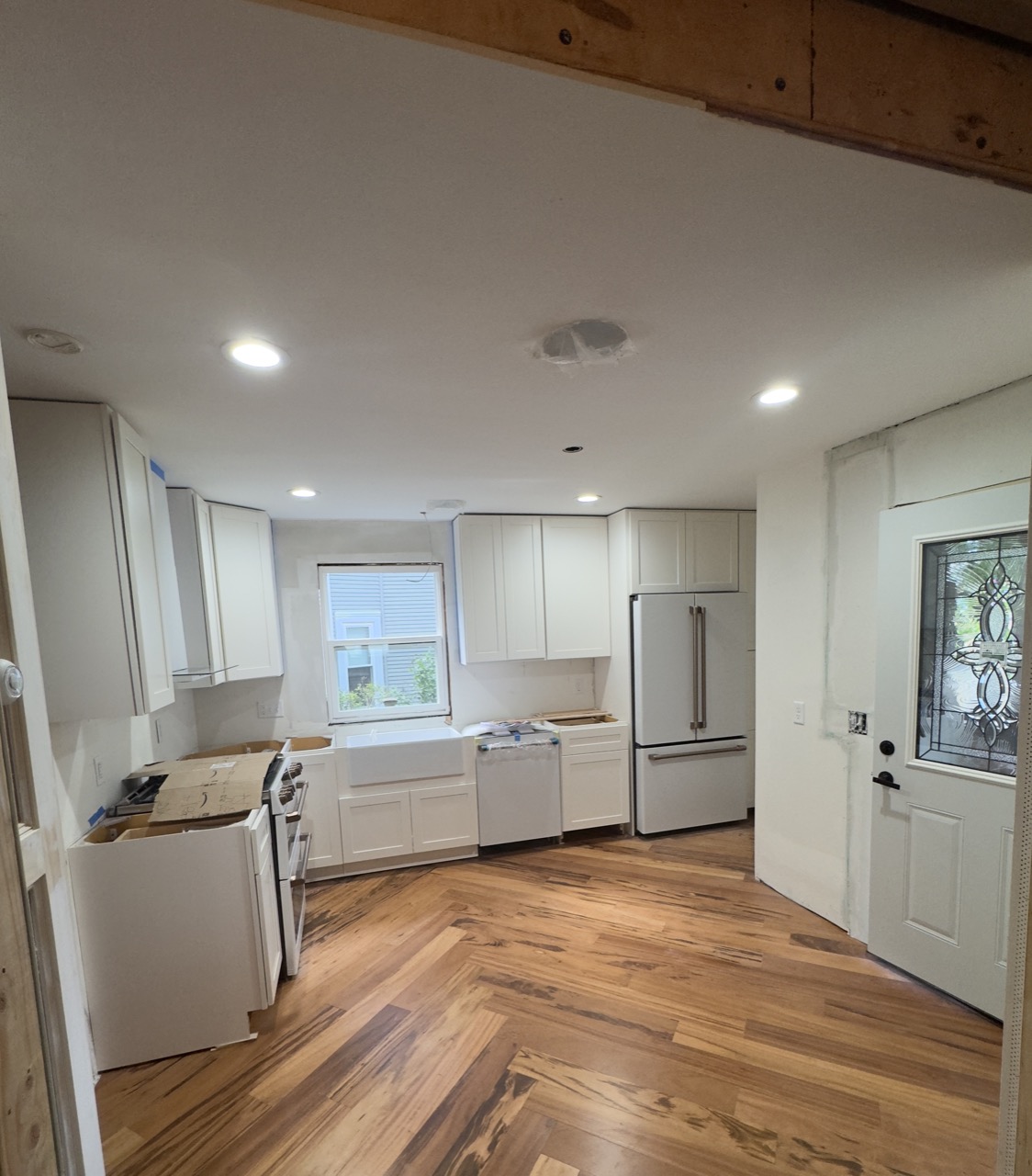Kitchen remodel complete — white cabinets, hardwood floors, stainless appliances